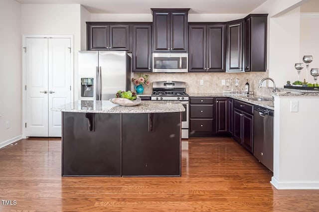 732 Suffield Way, Cary, NC 27519 - kitchen with appliances with stainless steel finishes, light stone countertops, light wood-type flooring, tasteful backsplash, and dark brown cabinets