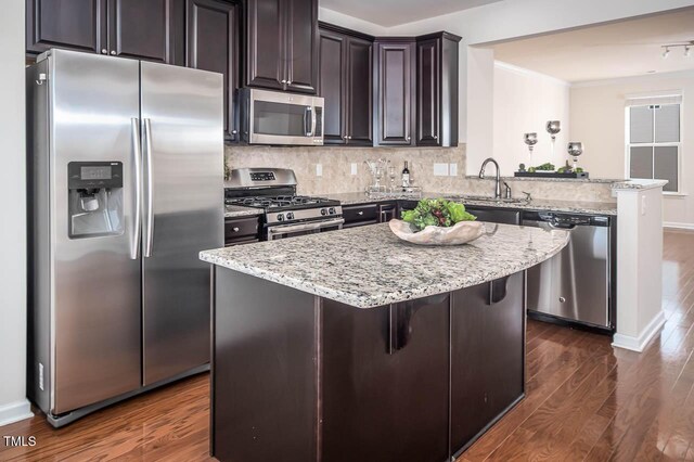 732 Suffield Way, Cary, NC 27519 - kitchen with stainless steel appliances, a peninsula, dark wood-style floors, light stone counters, and ornamental molding