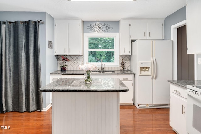 202 Howland Ave, Cary, NC 27513 - kitchen featuring white appliances, wood finished floors, decorative backsplash, and dark stone countertops
