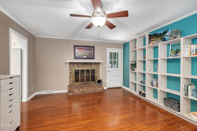 202 Howland Ave, Cary, NC 27513 - unfurnished living room with a ceiling fan, crown molding, wood finished floors, a textured ceiling, and a brick fireplace