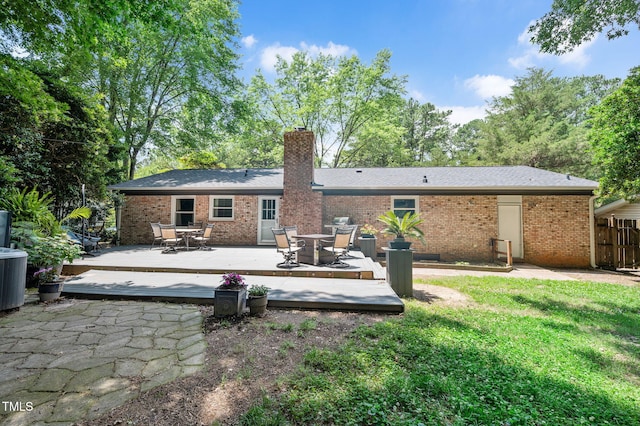 202 Howland Ave, Cary, NC 27513 - back of property with a wooden deck, outdoor dining space, a chimney, and brick siding