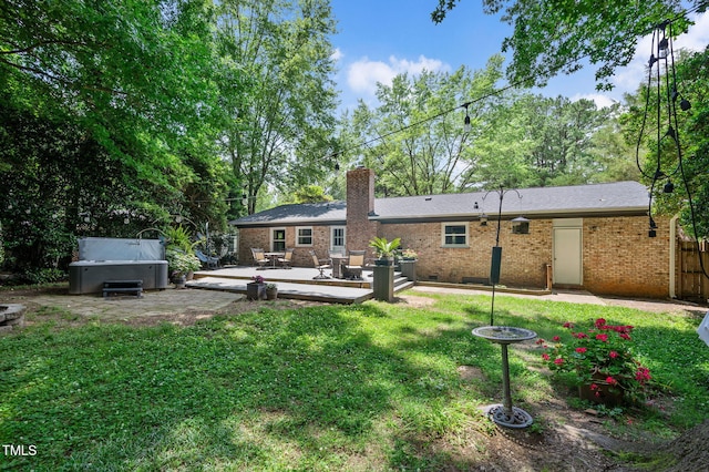 202 Howland Ave, Cary, NC 27513 - rear view of property featuring a deck, a chimney, a hot tub, and brick siding
