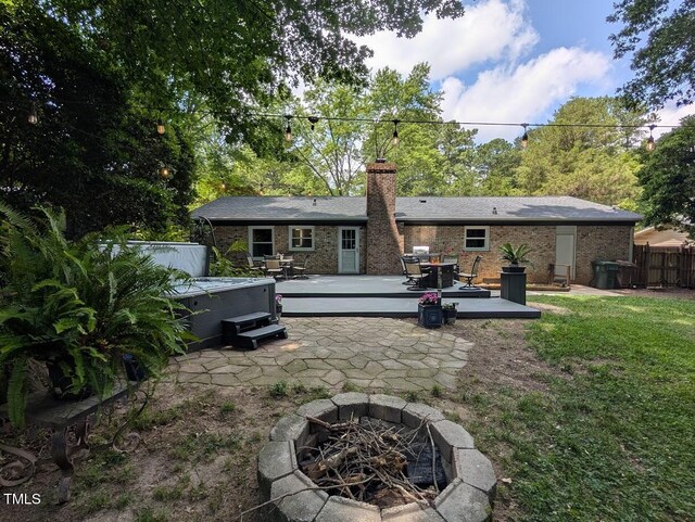 202 Howland Ave, Cary, NC 27513 - back of house with a fire pit, a hot tub, a wooden deck, a chimney, and a patio area