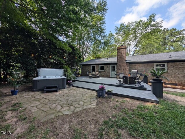 202 Howland Ave, Cary, NC 27513 - rear view of property featuring a hot tub, a wooden deck, outdoor dining area, and a chimney