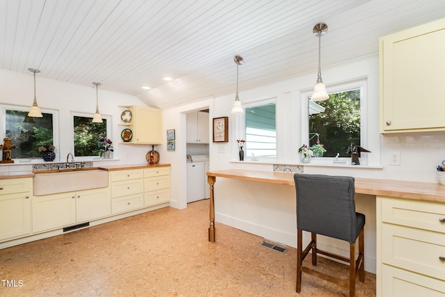 108 High St, Carrboro, NC 27510 - kitchen featuring wood counters, built in desk, washing machine and dryer, hanging light fixtures, and vaulted ceiling