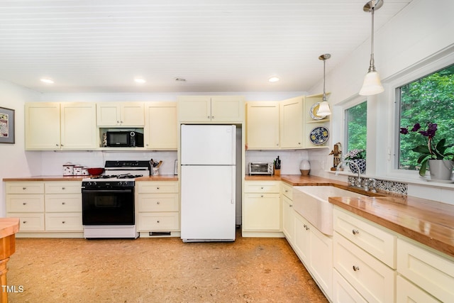 108 High St, Carrboro, NC 27510 - kitchen with freestanding refrigerator, gas range, butcher block counters, black microwave, and plenty of natural light