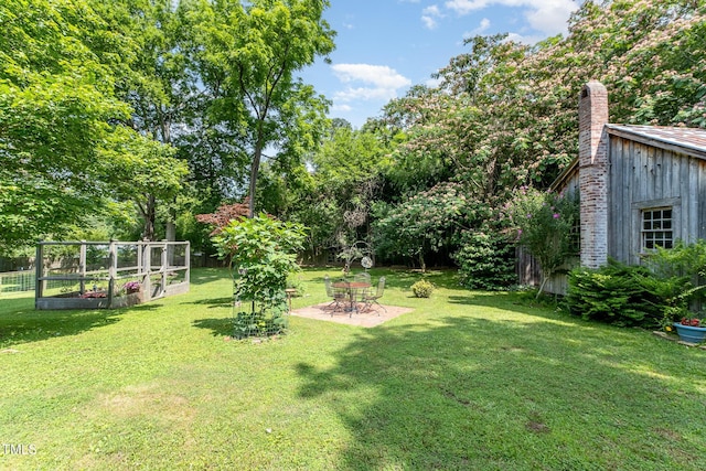 108 High St, Carrboro, NC 27510 - view of green lawn with a vegetable garden, a patio, and view of wooded area