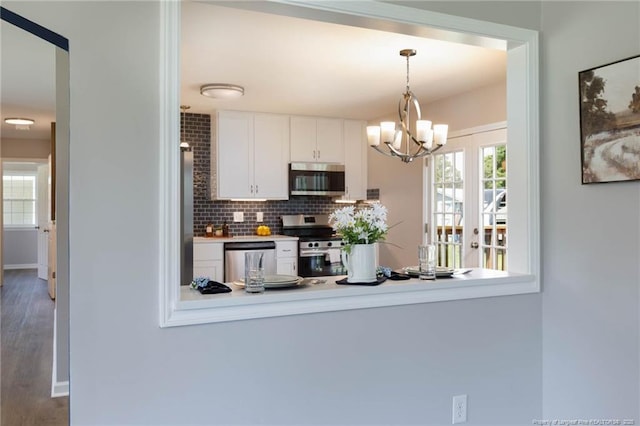 108 Pine St, Dunn, NC 28334 - kitchen with appliances with stainless steel finishes, white cabinets, a chandelier, tasteful backsplash, and decorative light fixtures