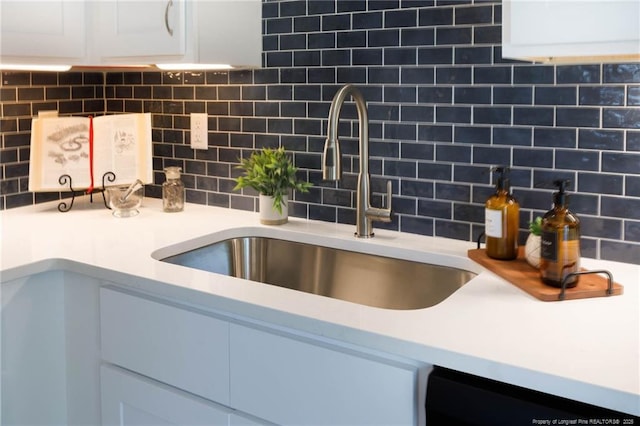 108 Pine St, Dunn, NC 28334 - kitchen view of a sink, dishwasher, tasteful backsplash, white cabinets, and light countertops