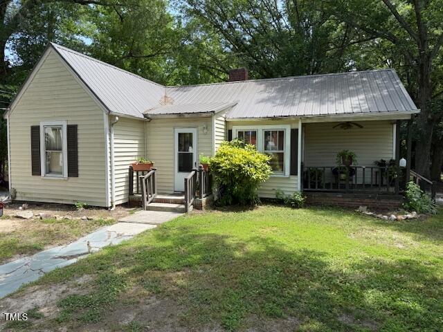 981 Leasburg Rd, Roxboro, NC 27573 - single story home with a front yard, a ceiling fan, a metal roof, a porch, and a chimney