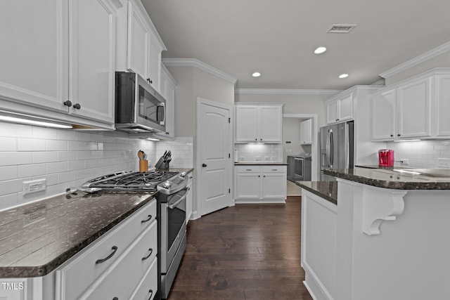 427 Cedar Pond Ct, Knightdale, NC 27545 - kitchen featuring stainless steel appliances, tasteful backsplash, white cabinets, crown molding, and dark wood-type flooring