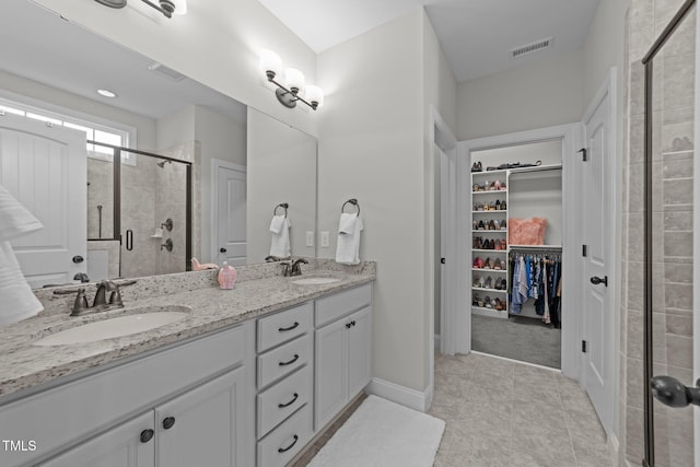 427 Cedar Pond Ct, Knightdale, NC 27545 - full bathroom with a stall shower, double vanity, a walk in closet, and tile patterned floors