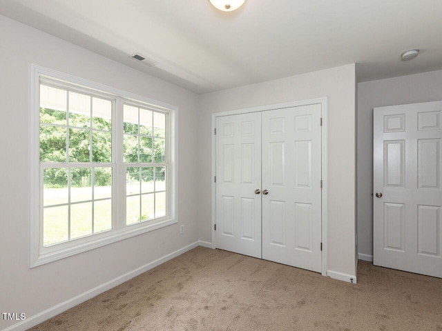 381 Gray Ghost Ln, Benson, NC 27504 - unfurnished bedroom featuring carpet, multiple windows, and a closet