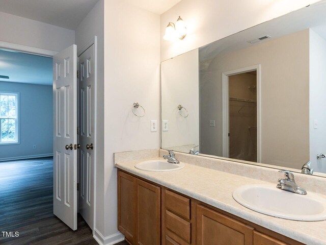 381 Gray Ghost Ln, Benson, NC 27504 - bathroom with wood finished floors, double vanity, and a spacious closet