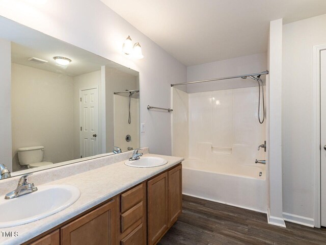 381 Gray Ghost Ln, Benson, NC 27504 - bathroom with wood finished floors, double vanity, and shower / washtub combination