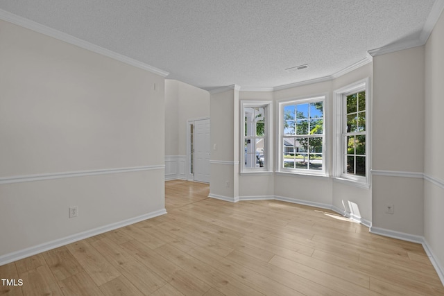 103 Burham Ct, Apex, NC 27502 - spare room featuring a textured ceiling, light wood-style flooring, crown molding, and baseboards