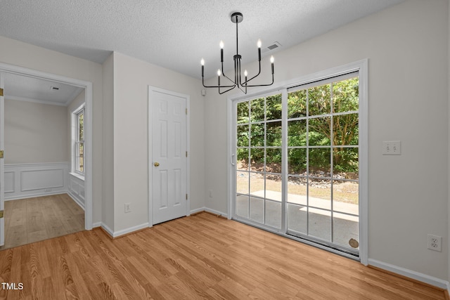 103 Burham Ct, Apex, NC 27502 - unfurnished dining area featuring a chandelier, light wood finished floors, and a textured ceiling