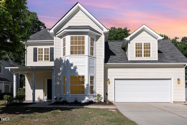1148 Dexter Ridge Dr, Holly Springs, NC 27540 - view of front of property featuring driveway, an attached garage, a shingled roof, and a porch