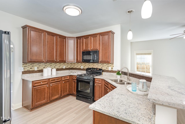 1148 Dexter Ridge Dr, Holly Springs, NC 27540 - kitchen featuring black appliances, a peninsula, light wood-style floors, and decorative backsplash