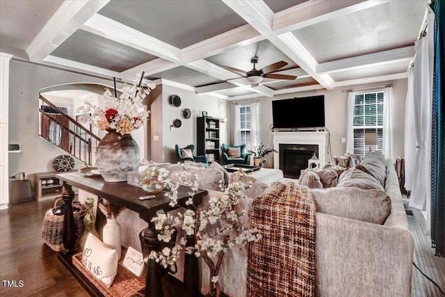 728 Opposition Way, Wake Forest, NC 27587 - living room featuring a glass covered fireplace, beam ceiling, a ceiling fan, coffered ceiling, and wood finished floors