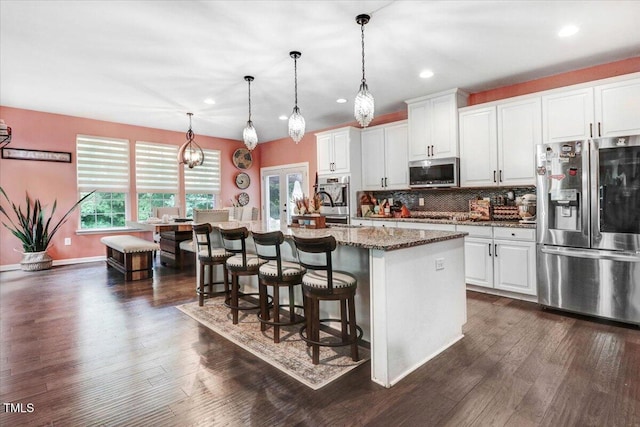 728 Opposition Way, Wake Forest, NC 27587 - kitchen featuring stainless steel appliances, a kitchen bar, recessed lighting, backsplash, and white cabinetry