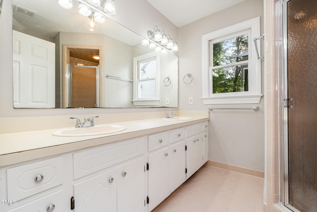 2629 Hiking Trl, Raleigh, NC 27615 - full bath featuring double vanity, a stall shower, tile patterned floors, and plenty of natural light