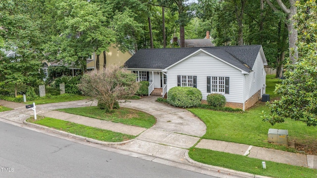 2629 Hiking Trl, Raleigh, NC 27615 - view of front of home featuring a front yard, curved driveway, roof with shingles, and view of scattered trees