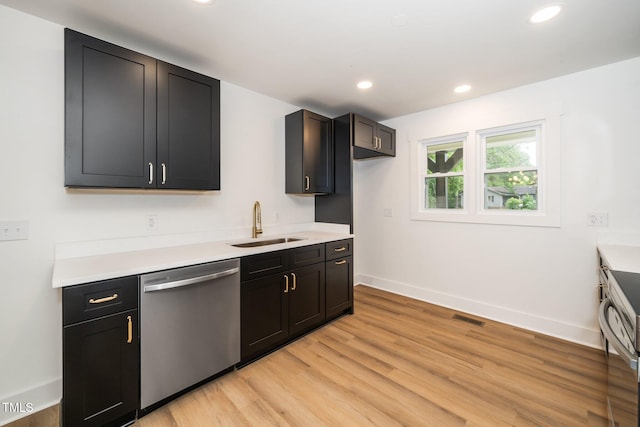 1308 Broken Branch Ct, Raleigh, NC 27610 - kitchen featuring dishwasher, light wood-style floors, light countertops, recessed lighting, and dark cabinets