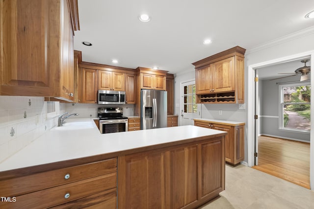 3517 Eden Croft Dr, Raleigh, NC 27612 - kitchen with appliances with stainless steel finishes, crown molding, a peninsula, light countertops, and brown cabinets