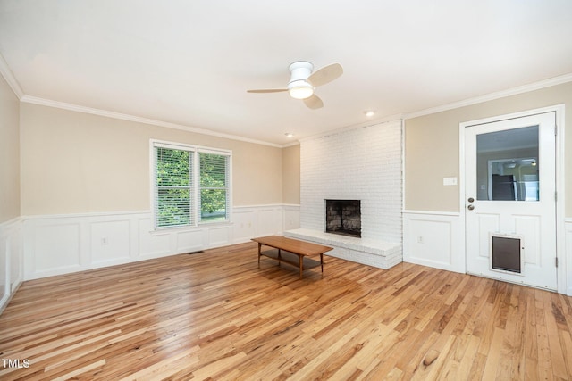 3913 Littlefield Ct, Raleigh, NC 27606 - unfurnished living room featuring light wood-type flooring, ceiling fan, crown molding, a fireplace, and a wainscoted wall
