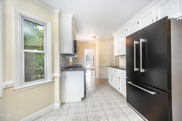 3913 Littlefield Ct, Raleigh, NC 27606 - kitchen with high end fridge, tasteful backsplash, white cabinets, light tile patterned floors, and ornamental molding