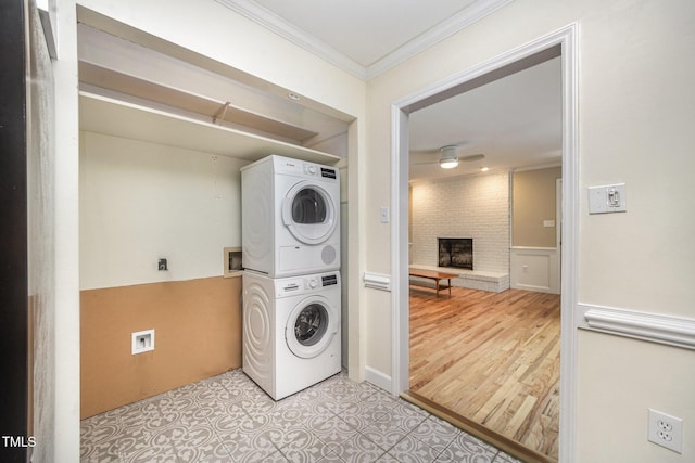 3913 Littlefield Ct, Raleigh, NC 27606 - laundry room with estacked washer and dryer, ornamental molding, a brick fireplace, wainscoting, and ceiling fan