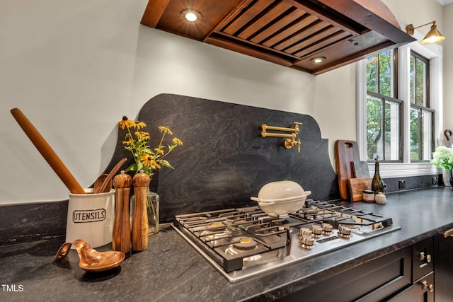 210 E Trinity Ave, Durham, NC 27701 - kitchen view of stainless steel gas stovetop, dark countertops, tasteful backsplash, pot filler, and custom exhaust hood
