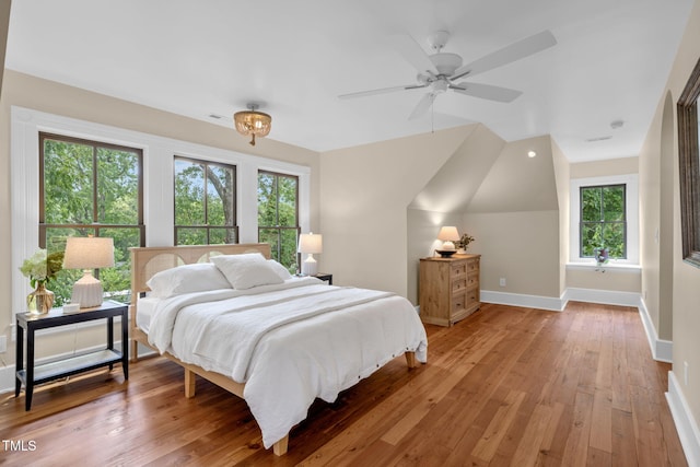 210 E Trinity Ave, Durham, NC 27701 - bedroom featuring multiple windows, light wood-style floors, and lofted ceiling