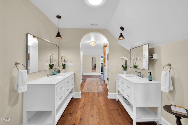 210 E Trinity Ave, Durham, NC 27701 - bathroom featuring two vanities, wood finished floors, and vaulted ceiling