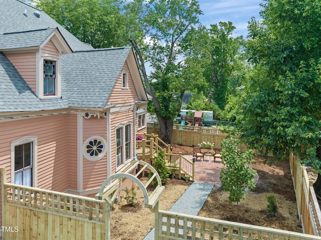 210 E Trinity Ave, Durham, NC 27701 - view of home's exterior with roof with shingles, a fenced backyard, and a patio