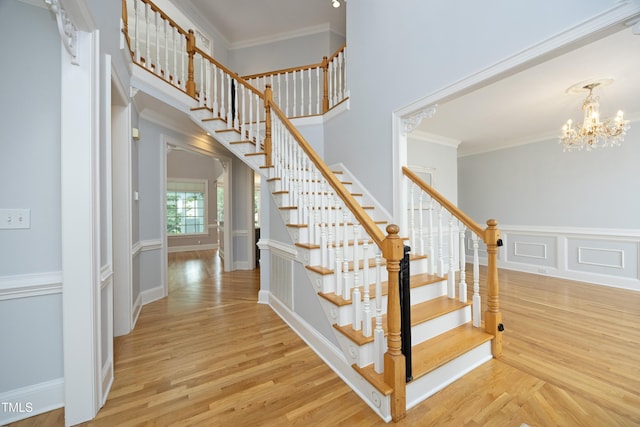 4217 Grahamstone Rd, Raleigh, NC 27610 - stairs featuring wood finished floors, a chandelier, and ornamental molding
