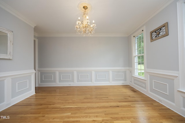 4217 Grahamstone Rd, Raleigh, NC 27610 - unfurnished dining area with a chandelier, light wood-style flooring, crown molding, wainscoting, and a decorative wall