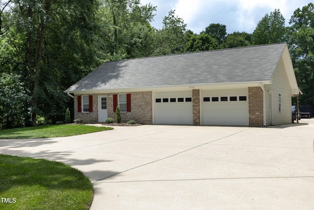4217 Grahamstone Rd, Raleigh, NC 27610 - view of front of property featuring brick siding, a garage, driveway, and a front lawn
