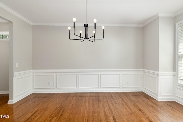 1304 Trailing Rose Ct, Wake Forest, NC 27587 - unfurnished dining area featuring a chandelier, wood finished floors, a wainscoted wall, and ornamental molding