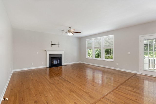 1304 Trailing Rose Ct, Wake Forest, NC 27587 - unfurnished living room with wood finished floors, plenty of natural light, a ceiling fan, and a fireplace with flush hearth