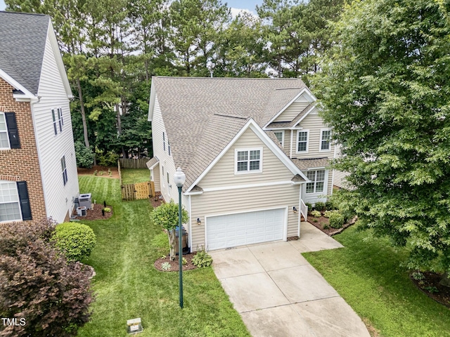 1304 Trailing Rose Ct, Wake Forest, NC 27587 - traditional home with concrete driveway, a garage, roof with shingles, and view of wooded area