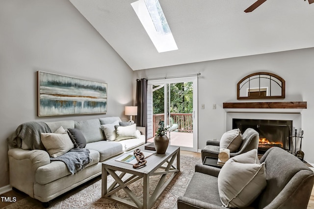 311 Westbrook Dr, Carrboro, NC 27510 - living room featuring a skylight, a glass covered fireplace, wood finished floors, high vaulted ceiling, and a ceiling fan