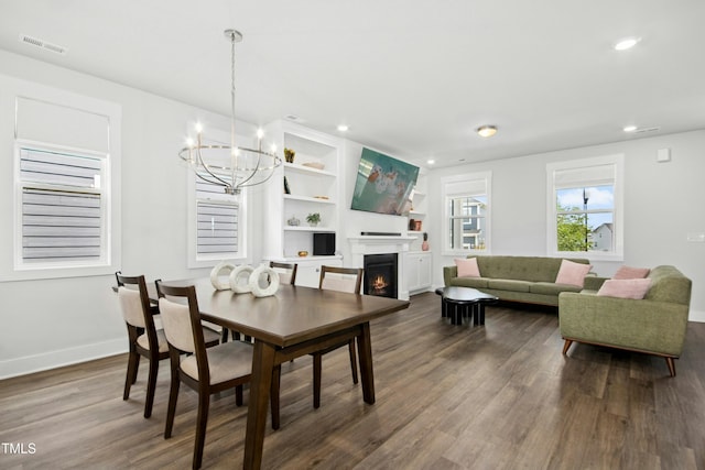 513 Basin Hill Dr, Wake Forest, NC 27587 - dining room featuring a chandelier, dark wood-style floors, a warm lit fireplace, and recessed lighting