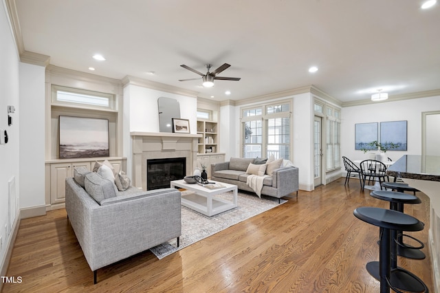 1217 Chalk Maple Dr, Cary, NC 27519 - living area featuring crown molding, ceiling fan, a glass covered fireplace, light wood-style floors, and recessed lighting