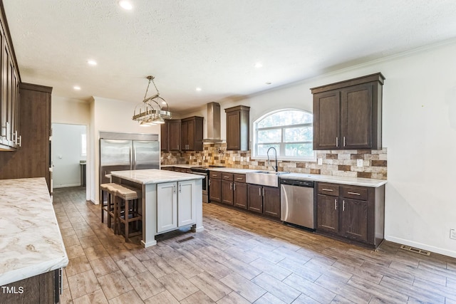 589 Atkinson Mill Rd, Selma, NC 27576 - kitchen with stainless steel appliances, wall chimney range hood, dark brown cabinetry, recessed lighting, and ornamental molding