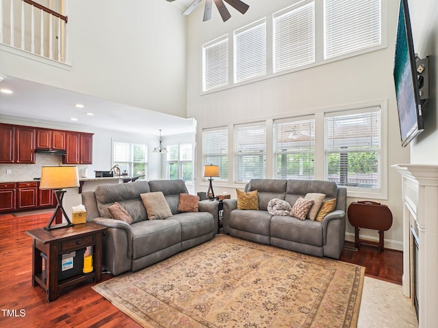 214 Ashdown Forest Ln, Cary, NC 27519 - living room with a ceiling fan, a high ceiling, dark wood-type flooring, a fireplace with flush hearth, and plenty of natural light
