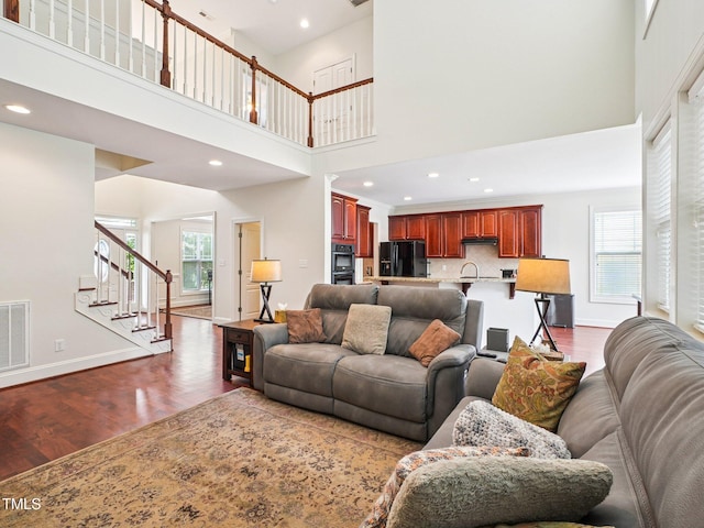 214 Ashdown Forest Ln, Cary, NC 27519 - living area with dark wood finished floors, stairway, healthy amount of natural light, a high ceiling, and recessed lighting