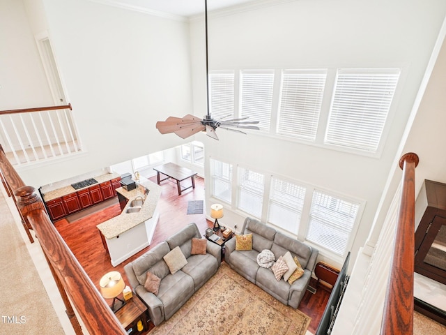 214 Ashdown Forest Ln, Cary, NC 27519 - living room featuring stairs, ornamental molding, a towering ceiling, ceiling fan, and light wood-type flooring