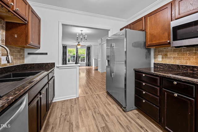 9908 Jerome Ct, Raleigh, NC 27617 - kitchen featuring appliances with stainless steel finishes, light wood-style floors, a chandelier, ornamental molding, and backsplash